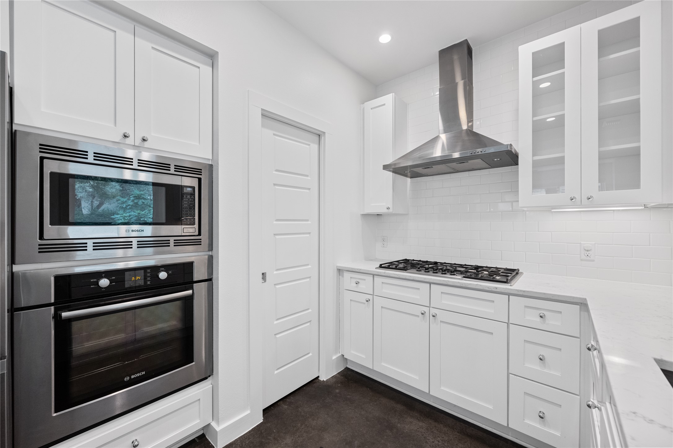 1303 Azie Morton Road, Unit 3 Austin, TX 78704 - Photo 4 of 24 a kitchen with white cabinets stainless steel appliances and wooden floor