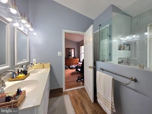 a en suite bathroom with a double vanity sink a mirror and a shower
