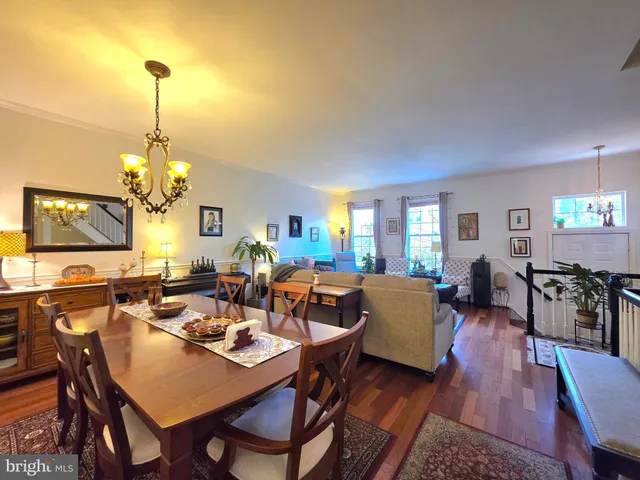 a living room with lots of furniture dining table and a chandelier