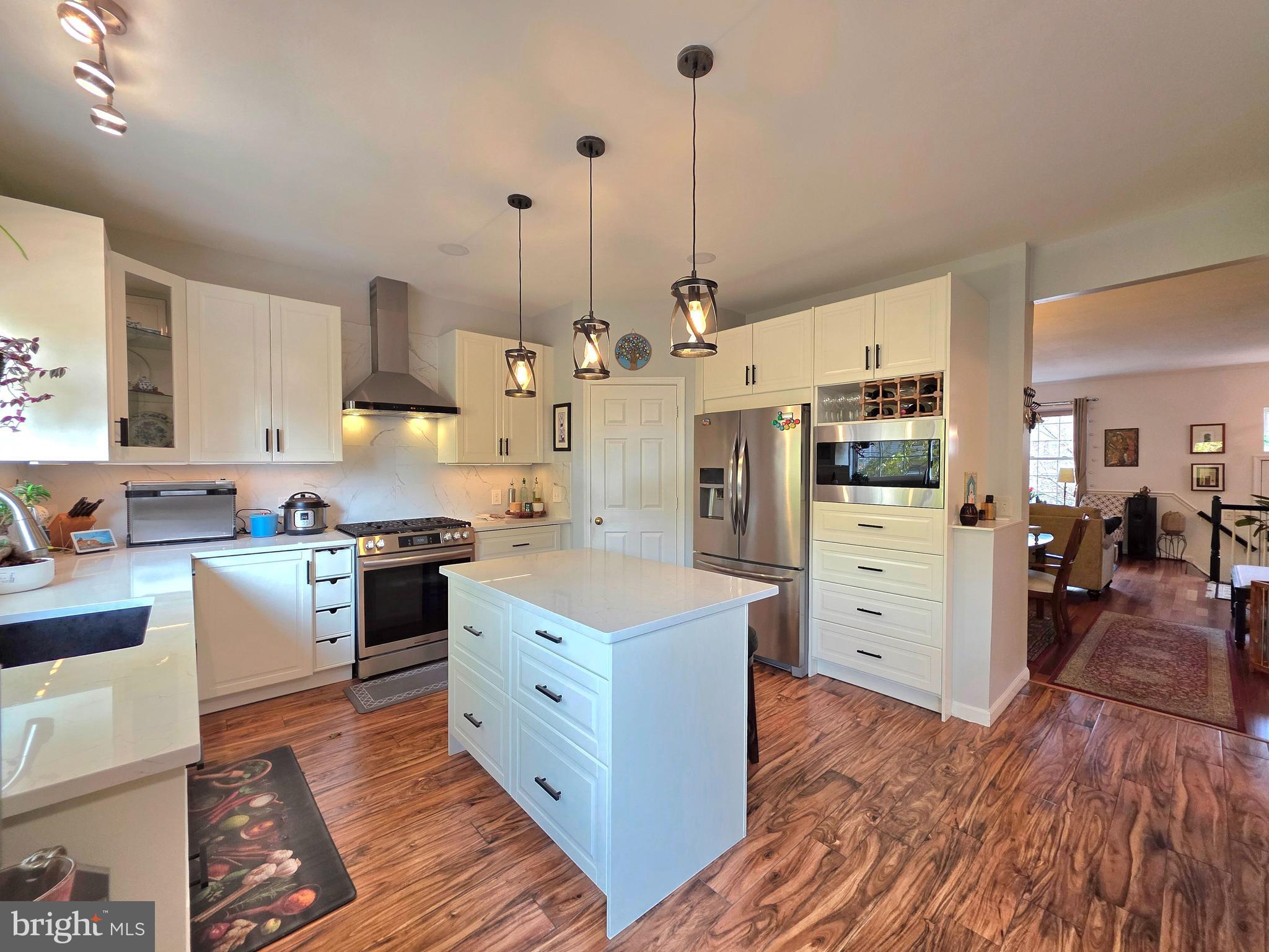 2826 Roesh Way Vienna, VA 22181 - Photo 9 of 36 a kitchen with stainless steel appliances kitchen island granite countertop a sink a stove and a wooden floors
