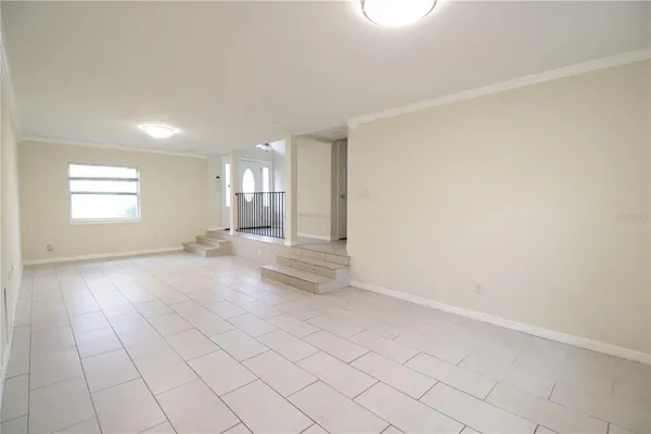 an empty room with window mirror and fan