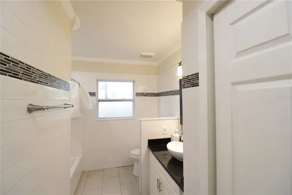 an empty room with wooden floor and chandelier fan