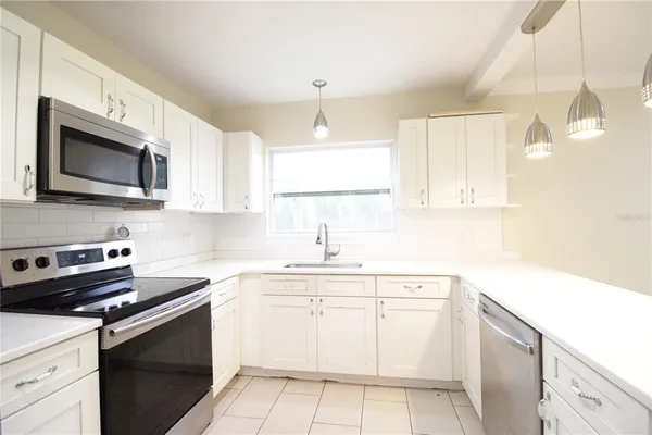 a kitchen with a sink stove and microwave