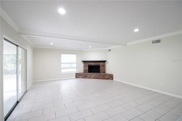 an empty room with fireplace and windows