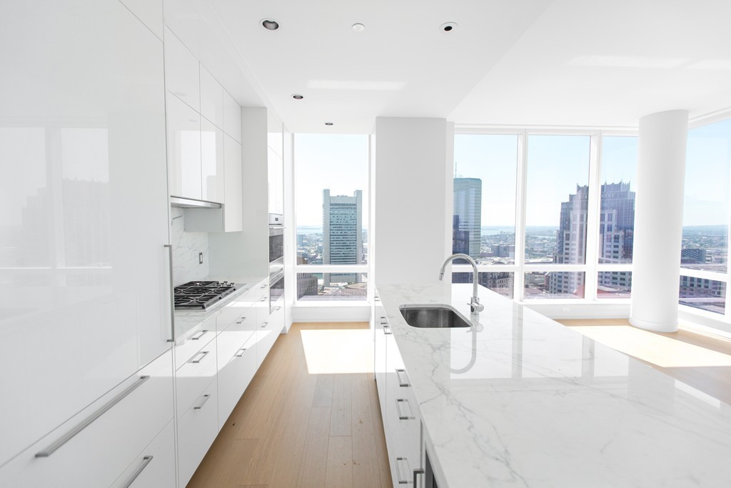 1 Franklin Street, Unit 4110 Boston, MA 02110 - Photo 2 of 8 a large white room with a large window and a view of bedroom with wooden floor