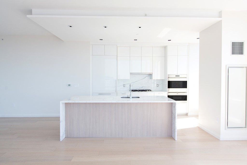 1 Franklin Street, Unit 4110 Boston, MA 02110 - Photo 4 of 8 a kitchen with stainless steel appliances a sink a stove and a refrigerator