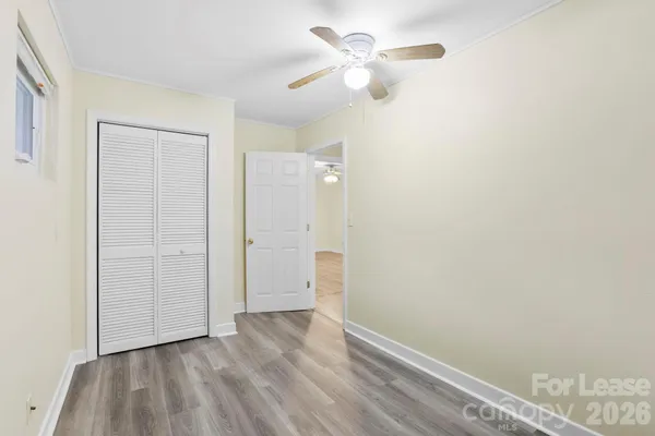 an empty room with closet and a ceiling fan