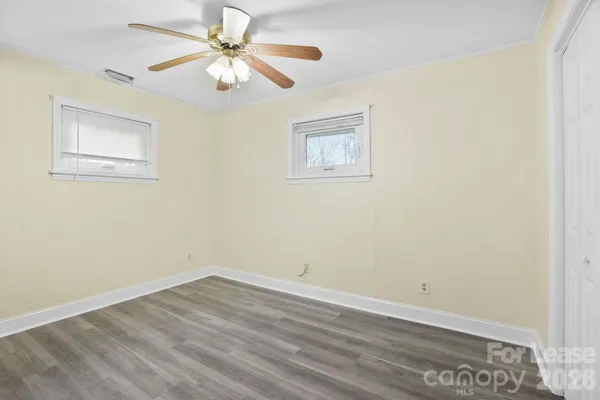 a view of a room with wooden floor and a ceiling fan