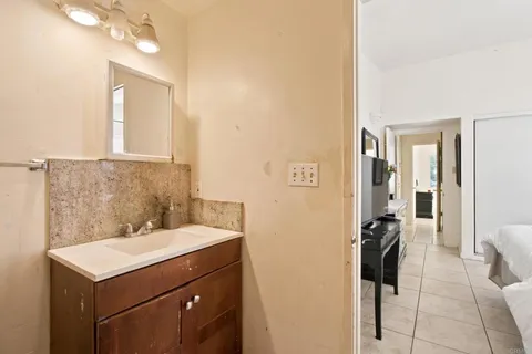 a bathroom with a sink a light fixture and a mirror