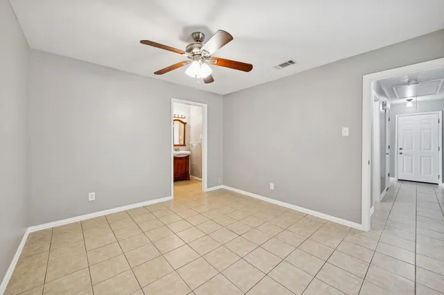 an empty room and chandelier fan