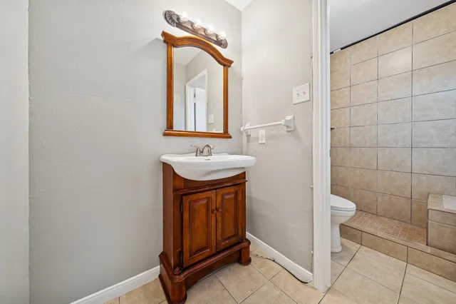 a bathroom with a sink a toilet and a mirror