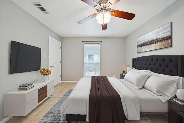 a bedroom with a large bed and a flat screen tv