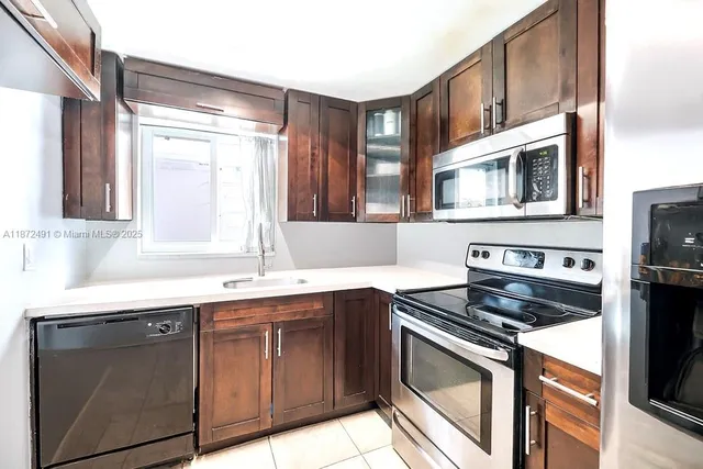 a kitchen with stainless steel appliances granite countertop a sink stove and microwave