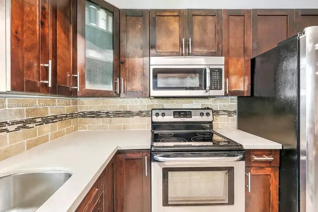 a kitchen with granite countertop a stove and a sink with granite counter tops