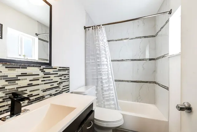 a bathroom with a sink a mirror toilet and bathtub