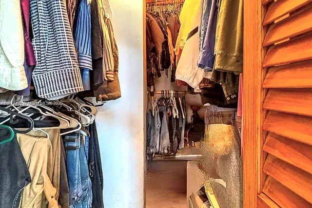 a view of walk in closet with clothes and shoes