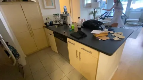 a kitchen with sink and view of living room
