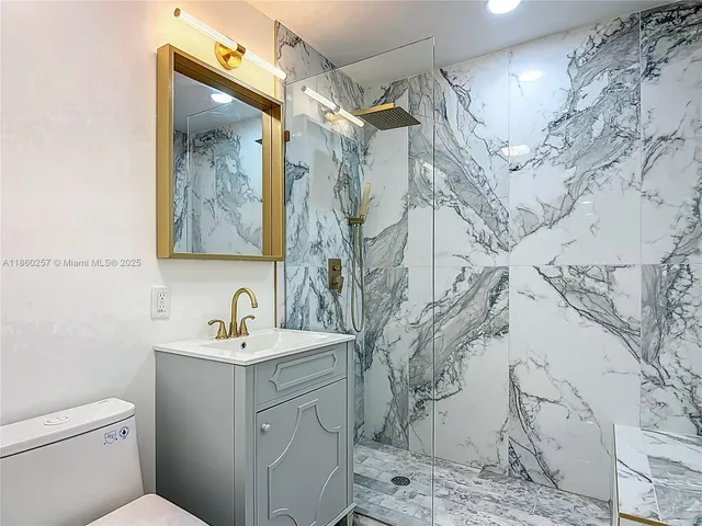 a bathroom with a sink and mirror with toilet