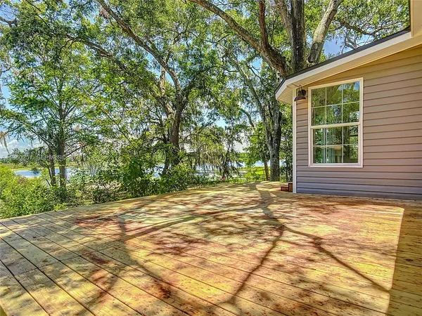 a view of a house with backyard and trees