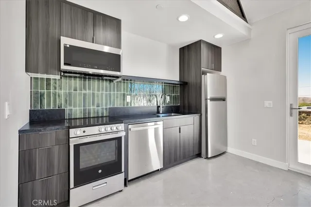 a kitchen with stainless steel appliances granite countertop a stove a refrigerator and a microwave