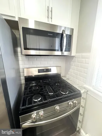 a stove top oven sitting inside of a kitchen