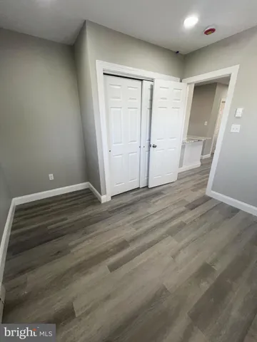 an empty room with wooden floor and closet