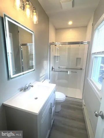a bathroom with a sink a toilet and a mirror