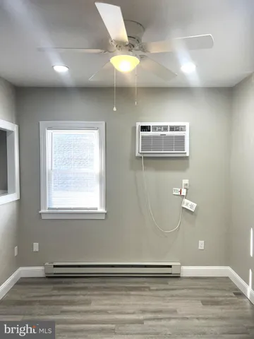 a view of a livingroom with wooden floor and a ceiling fan