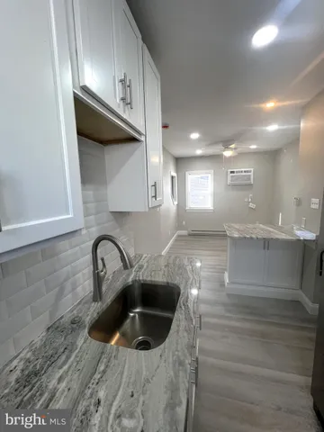 a kitchen with stainless steel appliances granite countertop a sink a stove and a wooden floors