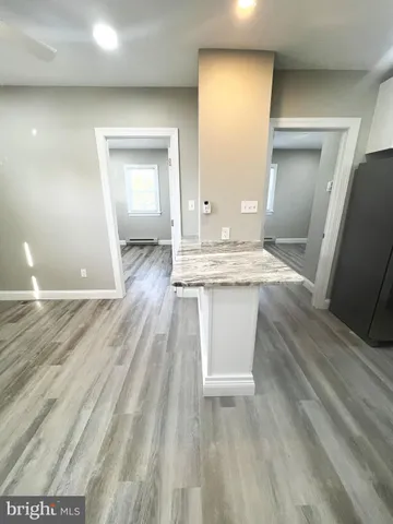 a room view with wooden floor and bathroom view
