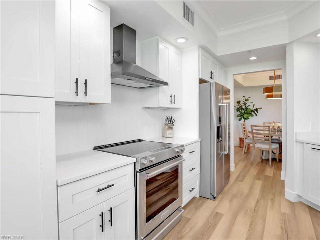 325 Dunes Boulevard, Unit 403 Naples, FL 34110 - Photo 12 of 49 a kitchen with stainless steel appliances granite countertop a stove and a refrigerator