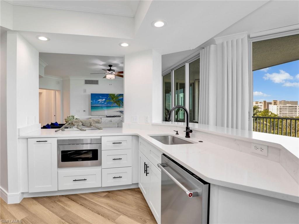 325 Dunes Boulevard, Unit 403 Naples, FL 34110 - Photo 14 of 49 a view with granite countertop a sink and white cabinets with wooden floor