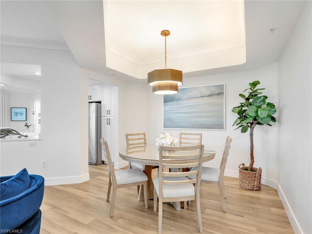 325 Dunes Boulevard, Unit 403 Naples, FL 34110 - Photo 19 of 49 a table and chairs in a room