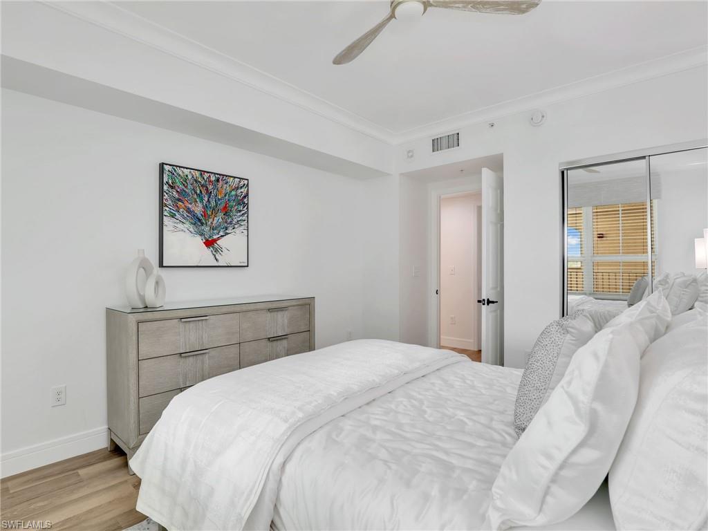 325 Dunes Boulevard, Unit 403 Naples, FL 34110 - Photo 30 of 49 a bedroom with a bed and a painting on the wall