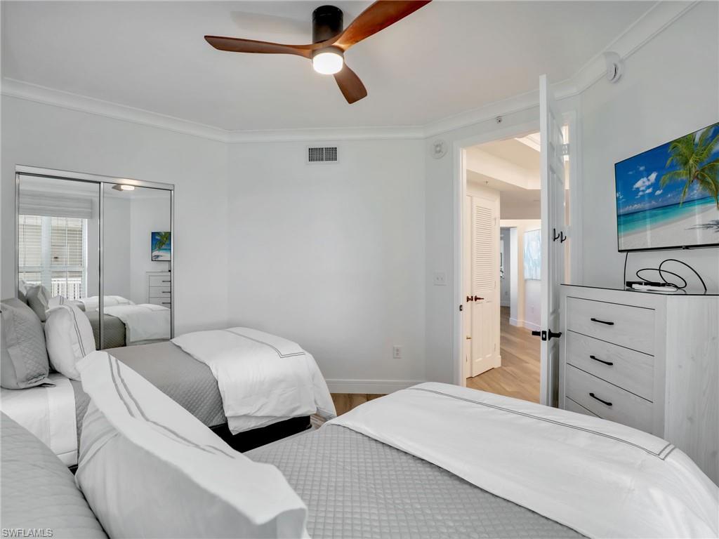 325 Dunes Boulevard, Unit 403 Naples, FL 34110 - Photo 33 of 49 a bedroom with a bed and a flat screen tv