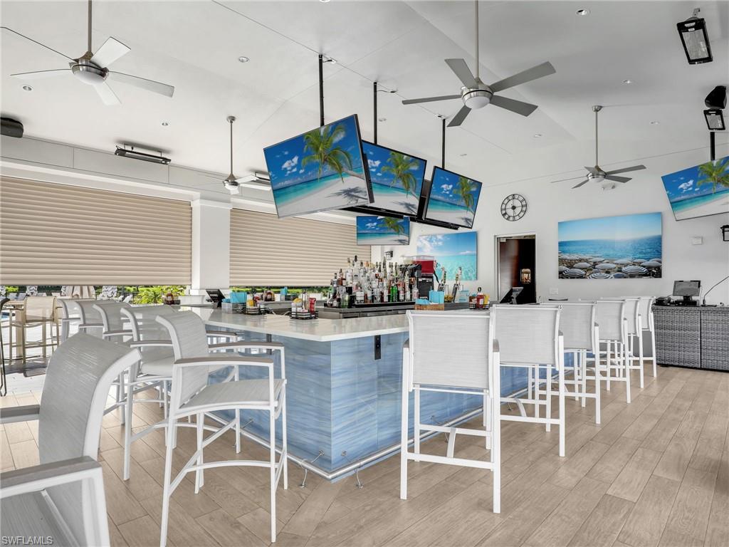 325 Dunes Boulevard, Unit 403 Naples, FL 34110 - Photo 41 of 49 a kitchen with stainless steel appliances kitchen island granite countertop a table and chairs in it