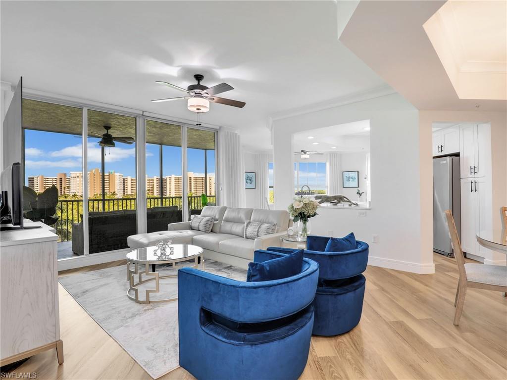 325 Dunes Boulevard, Unit 403 Naples, FL 34110 - Photo 8 of 49 a living room with furniture large windows and wooden floor