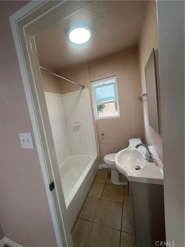 a bathroom with a sink a toilet a mirror and shower