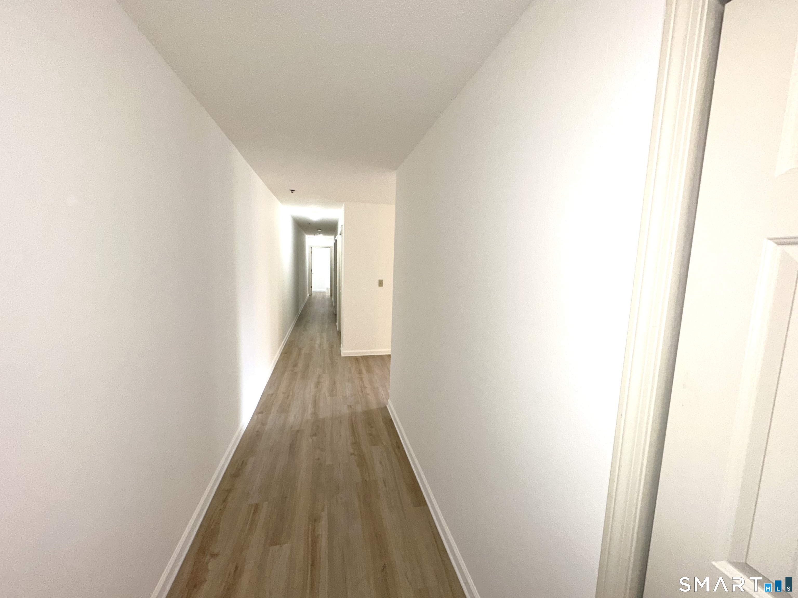 243 Judd Square, Unit 243 Wallingford, CT 06492 - Photo 10 of 17 a view of a hallway with wooden floor
