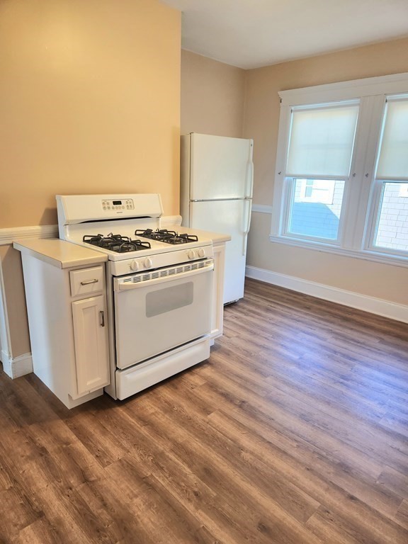 25 Glendower Road, Unit 2 Boston, MA 02131 - Photo 9 of 17 a kitchen with a stove and wooden floor