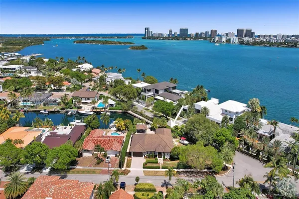 an aerial view of a city with lots of residential buildings ocean and mountain view in back