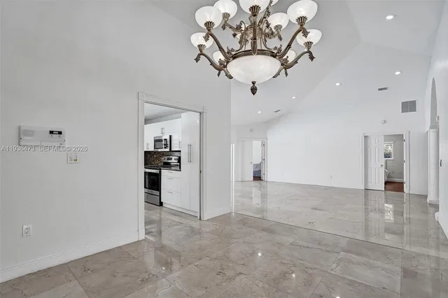a view of a kitchen with a sink and chandelier