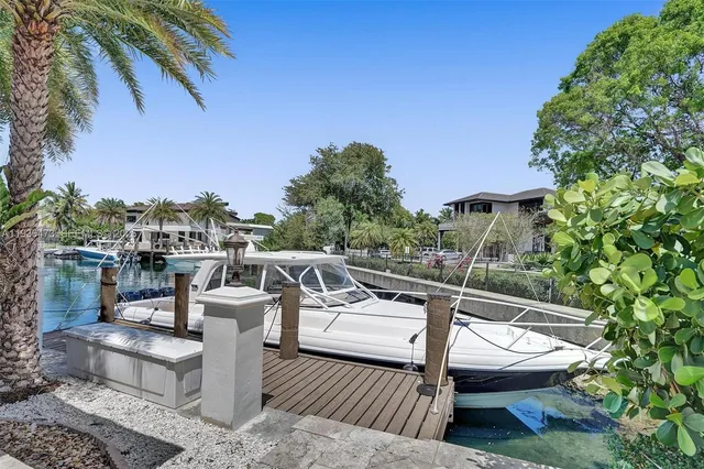 a view of a patio with table and chairs potted plants and palm tree