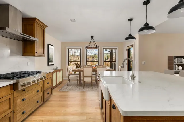 a spacious kitchen with stainless steel appliances granite countertop a sink stove and refrigerator
