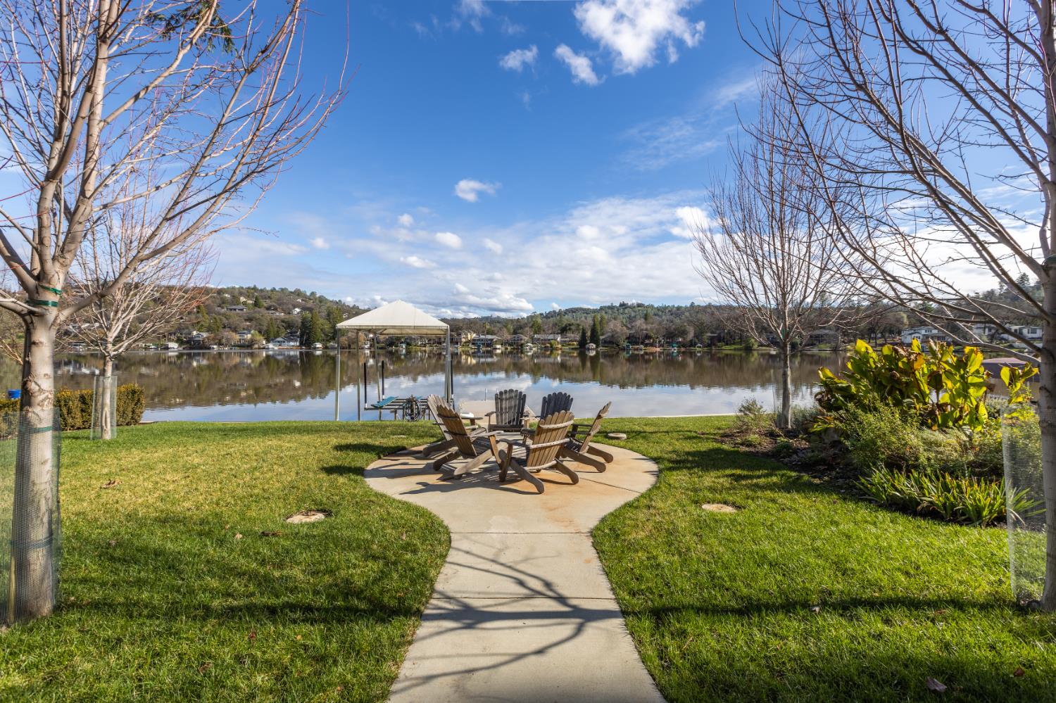 13859 Ginger Loop Penn Valley, CA 95946 - Photo 2 of 50 a view of a lake with couches and table and chairs under an umbrella