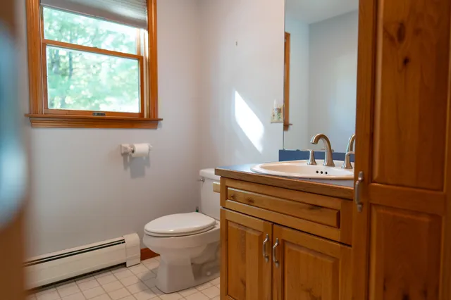 a kitchen with stainless steel appliances granite countertop a refrigerator a sink dishwasher and wooden cabinets with wooden floor