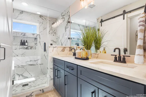 a bathroom with a double vanity sink mirror and shower