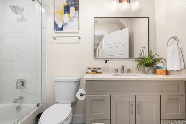a bathroom with a sink a toilet and a mirror