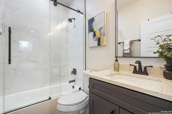 a bathroom with a sink a toilet and shower