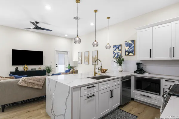 a view of a kitchen with kitchen island a sink stainless steel appliances and cabinets